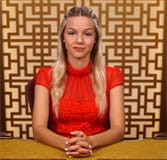 Das Bild zeigt die Baccarat-Dealerin Irina beim Kartengeben.