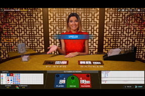 Hier wird der gelbe Baccarat Tisch von einer Dame in rotem Kleid bespielt.