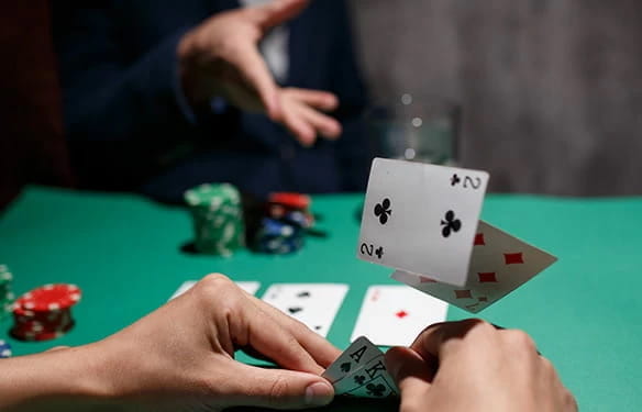 Ein Spieler schaut sich seine Karten an und der Mitspieler gegenüber foldet seine Karten.