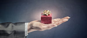 Auf einer geöffneten Handfläche befindet sich ein kleines Geschenkpaket. Weiterhin ist das Logo des Yggdrasil Online Casinos zu erkennen, das einen No Deposit Bonus anbietet.