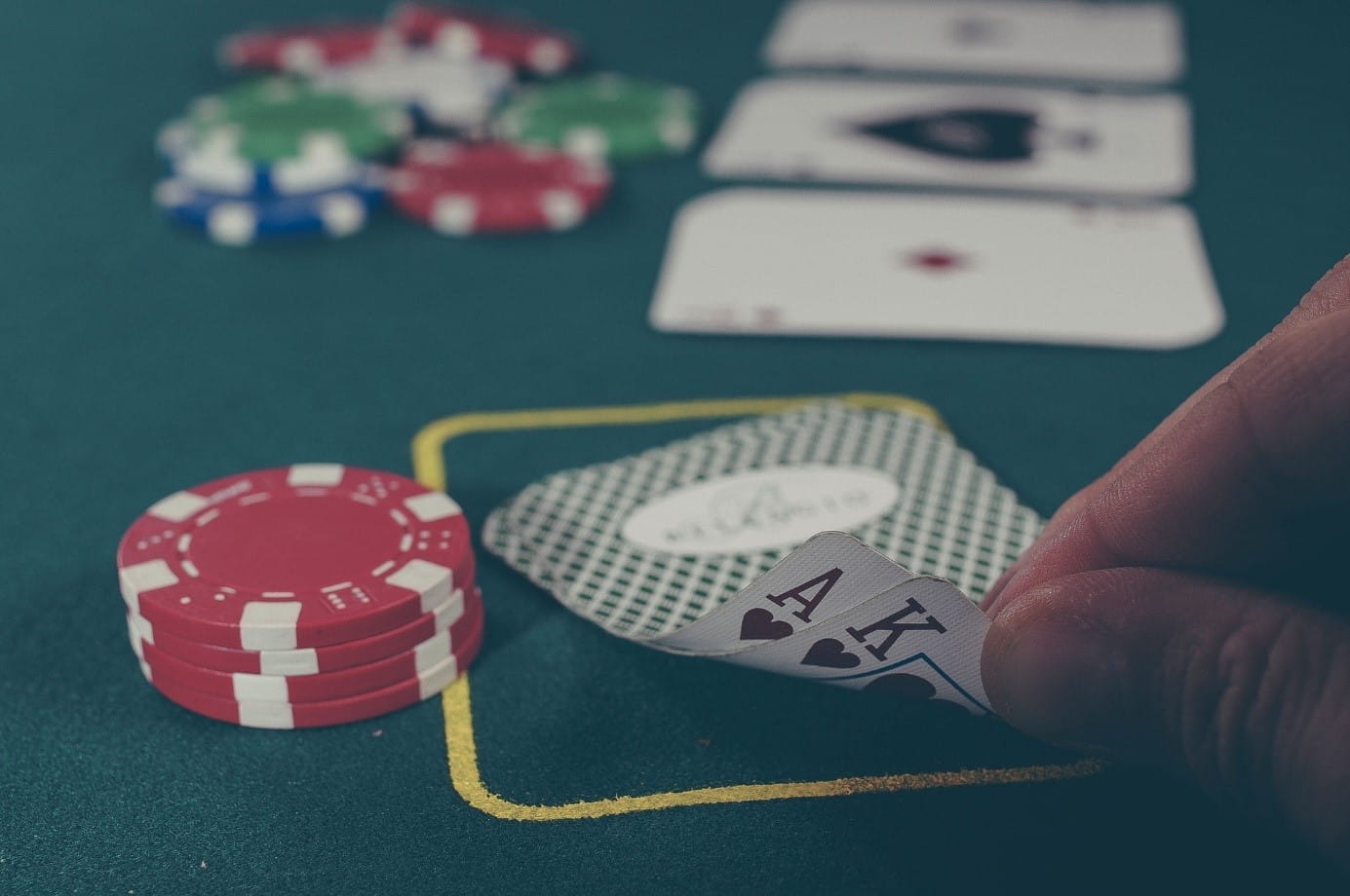 Spielkarten und Spielchips auf einem Poker-Tisch.