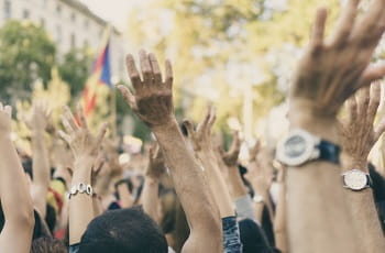 Demonstranten erheben ihre Hände.