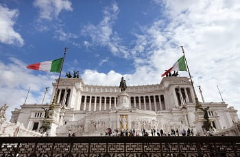 Italienische Flaggen vor einem römischen Monument.