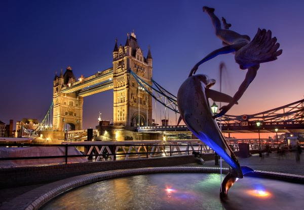 Tower Bridge in London bei Nacht in goldenem Licht teilweise beleuchtet.