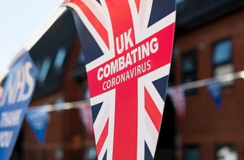 Ein britischer Wimpel warnt vor dem Coronavirus.