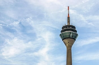 Der Düsseldorfer Rheinturm unter blauem Himmel.