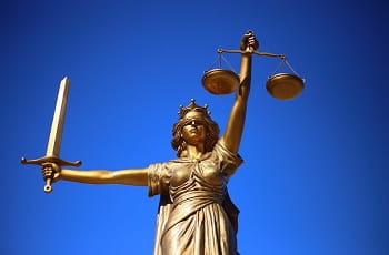 Eine Statue der Justitia unter blauem Himmel.