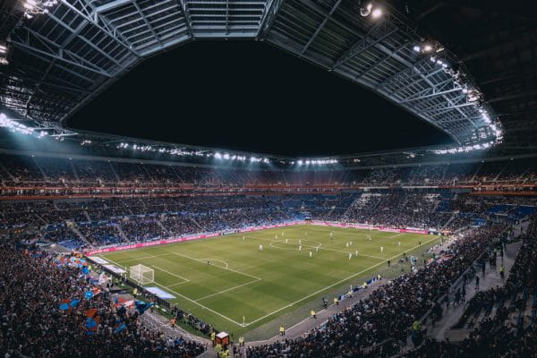 Gefülltes Stadion voller Werbebanden.